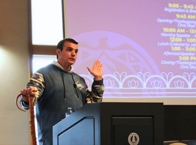 man standing at podium with arm raised