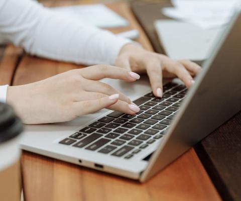 hands typing on laptop