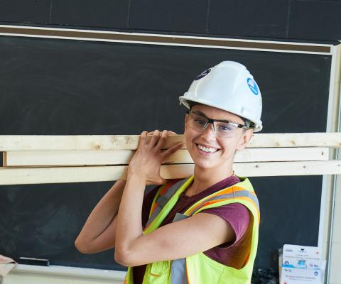 construction woman carrying wood