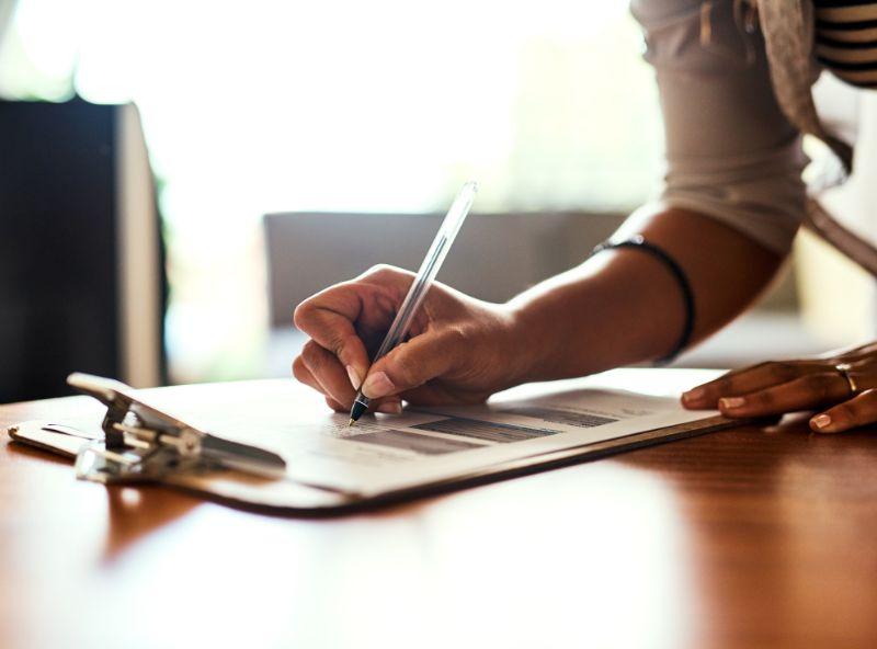 closeup of a hand filling out a form